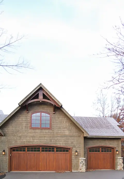 Double custom wood garage door with a classic design, enhancing the warmth and elegance of a traditional home.