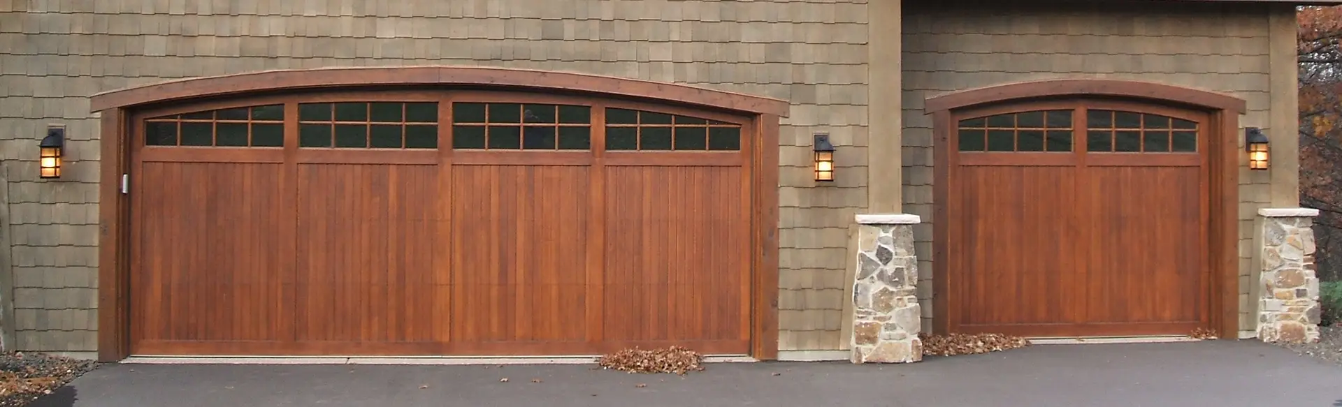 Double custom wood garage door with a classic design, enhancing the warmth and elegance of a traditional home.
