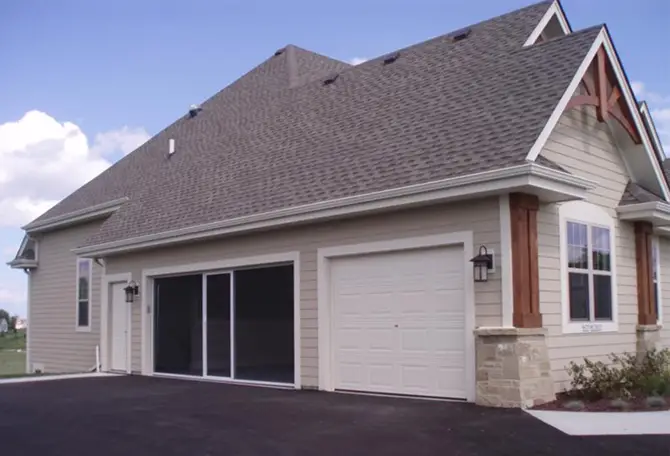 A house with a white garage door and a garage screen