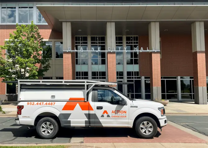 A white Action Overhead service truck idles outside the front door of the Blaine City Hall on a bright summer day in the Twin Cities.