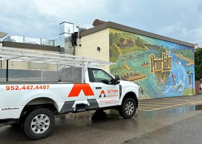 A white Action Overhead service truck is parked