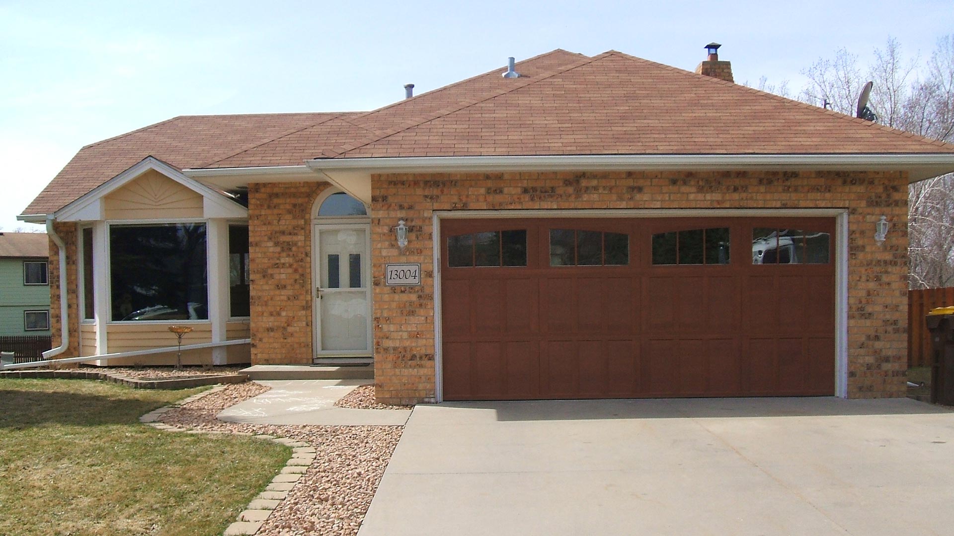 Residential double car garage door painted a burgundy color on a single family home.